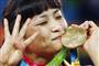 ８月、リオ五輪レスリングの女子５８キロ級で獲得した金メダルにキスをする４連覇達成の伊調馨選手＝リオデジャネイロ（共同）
