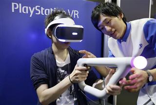 「東京ゲームショウ２０１６」で、ゴーグル型端末「プレイステーションＶＲ」を体験する男性＝１５日午前、千葉市の幕張メッセ