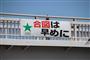 岡山市内の交差点の歩道橋には「合図は早めに」や「右左折の合図は３０メートル手前で」と書かれた横断幕が設置されている＝同市北区