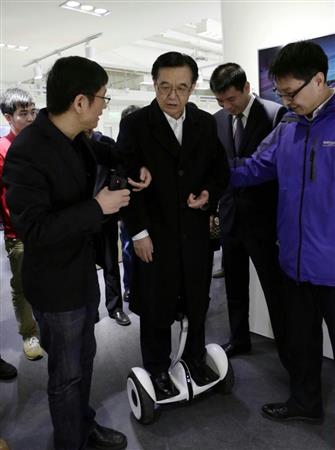 北京市内の商店街視察で今年２月、立ち乗り電動二輪車に試乗する高虎城商務相（中国新聞社）