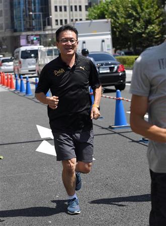 暑さを和らげるための特殊な舗装が施された道路を試走する瀬古利彦さん＝８月、東京都渋谷区