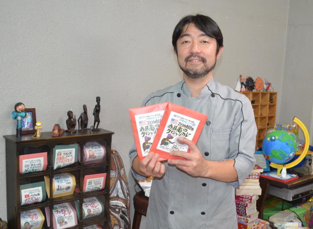 アカミミガメのレトルトカレーを手にする本山尚義さん＝神戸市東灘区
