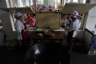 中国河北省石家荘市の山間部にある小学校で、校内の食堂で支給される無料の給食を食べるために並ぶ児童たち（中国新聞社）