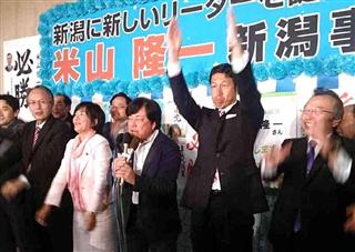 開票速報で当確が伝えられ、万歳をして喜ぶ米山隆一氏（右から２人目）と陣営の幹部ら＝１６日午後９時２０分、新潟市中央区