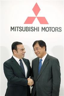 会見で握手を交わす、三菱自動車の会長に就任することが決まった日産自動車のカルロス・ゴーン社長（左）と三菱自動車の益子修社長＝２０日午後、東京都港区（福島範和撮影）