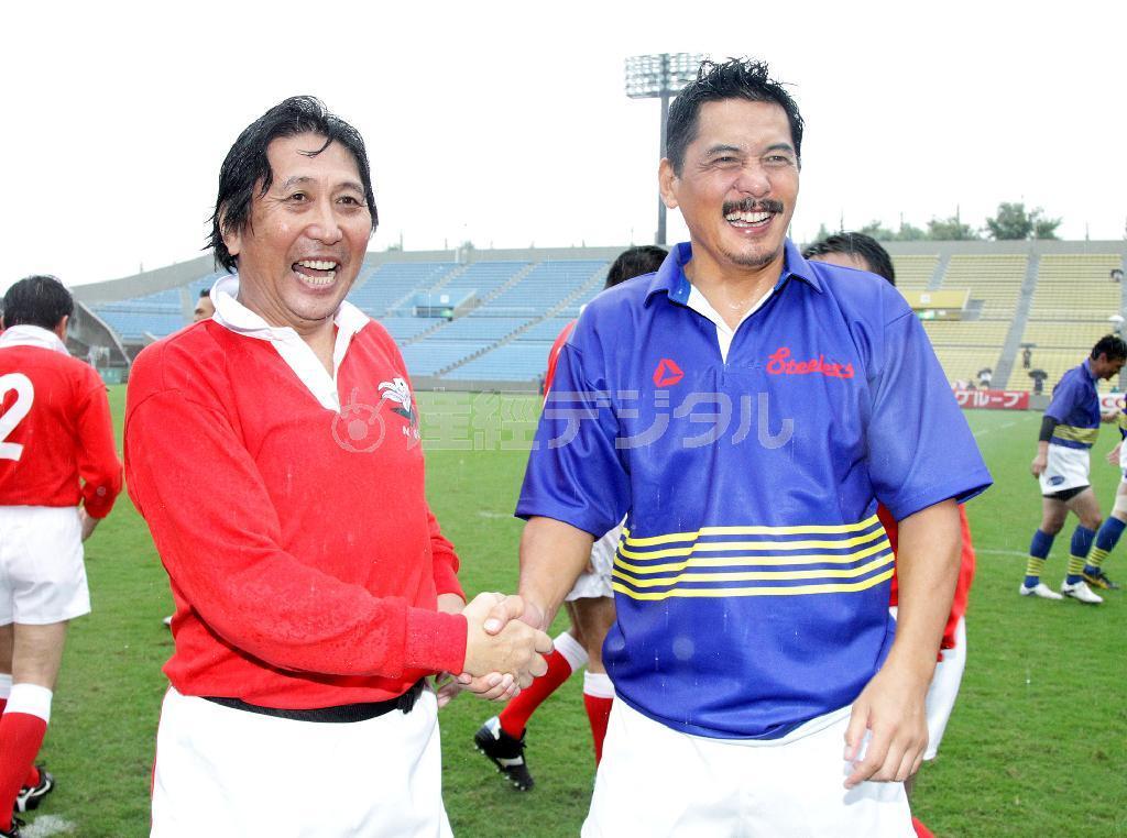 【ラグビー】東日本大震災復興支援「Ｖ７戦士チャリティーマッチ」新日鐵釜石ＯＢ対神戸製鋼ＯＢ試合前握手する、新日鐵釜石ＯＢ・松尾雄治（左）と神戸製鋼ＯＢ・平尾誠二（右）＝東京・秩父宮ラグビー場（撮影・中井誠）