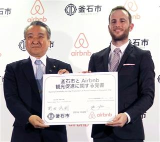 記念撮影に応じるエアビーアンドビーのジョー・ゲビア氏（右）と岩手県釜石市の野田武則市長＝２０日、東京都千代田区