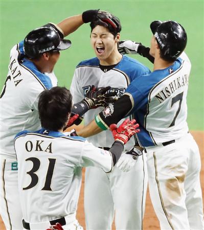 日本シリーズ第3戦、日本ハムが広島に延長10回4-3でサヨナラ勝ちして初白星を挙げた。決勝打を放った大谷翔平選手は中田選手(左端)らナインから手荒い祝福を受ける=25日、札幌ドーム