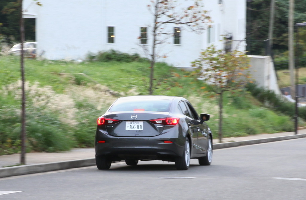 住宅街を走るマツダ「アクセラ」