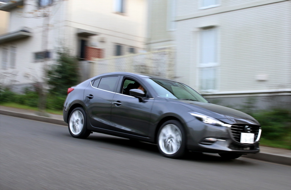 住宅街を走るマツダ「アクセラ」