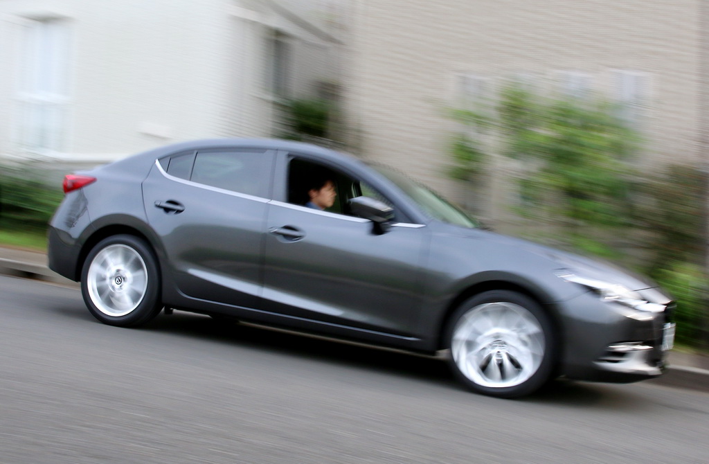 住宅街を走るマツダ「アクセラ」