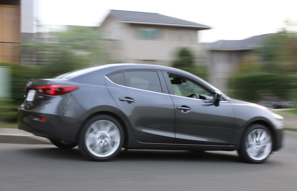 住宅街を走るマツダ「アクセラ」