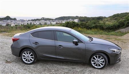 マツダ「アクセラ セダン」のサイドビュー。遠くに湘南の海を望む