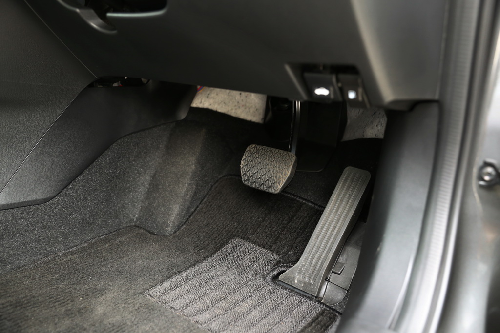 オルガン式アクセルペダルを採用することで、フロアにつけたかかとがずれにくいというメリットがある。足元は広々としていて運転しやすいのだが、ペダルの奥をよーく見るとむき出しが気になる。あちらこちらに配線も…