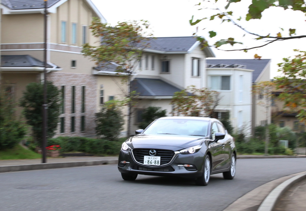 住宅街を走るマツダ「アクセラ」