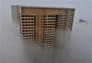 霞の中に建つ高層ビル＝２０１４年３月、安徽省合肥市（ロイター）