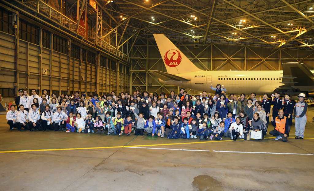 イベントの最後に格納庫で集合写真を撮影する参加者