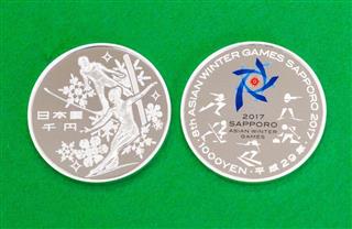 第８回冬季アジア大会を記念した千円硬貨。左が表面、右が裏面＝２４日午後、造幣局