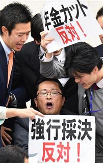 衆院厚生労働委員会で、年金制度改革関連法案の採決に反対し、丹羽秀樹委員長（中央下）に詰め寄る民進党の議員ら＝２５日午後、国会・衆院第１６委員室（斎藤良雄撮影）