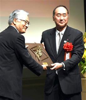 大賞を受賞し、須藤春夫審査委員長(左)から盾を贈られる三菱電機の萩原稔常務執行役=25日、東京・大手町 大賞を受賞し、須藤春夫審査委員長(左)から盾を贈られる三菱電機の萩原稔常務執行役=25日、東京・大手町