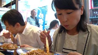 登別閻魔やきそばに舌鼓を打つ筆者（右）