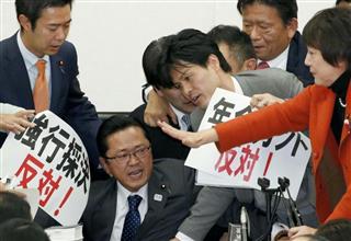 衆院厚労委で年金制度改革法案などの採決に反対し、丹羽秀樹委員長に詰め寄る民進、共産両党＝２５日午後
