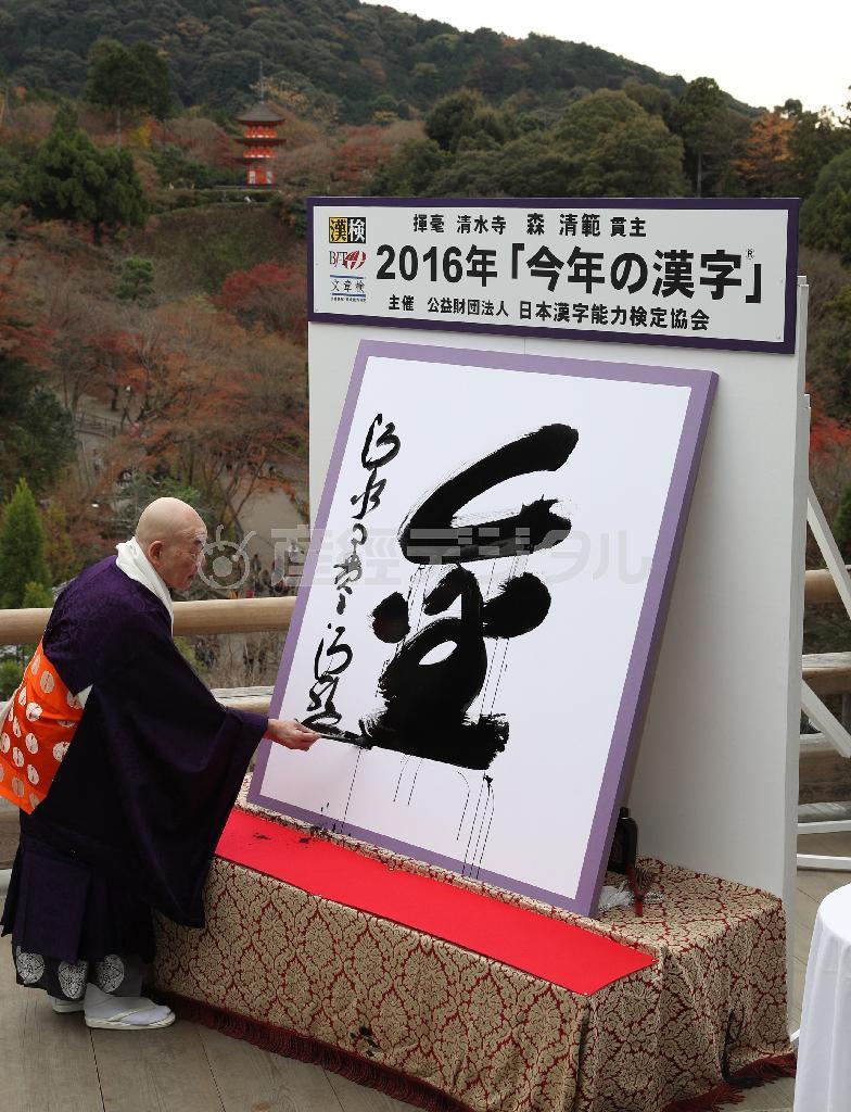 平成２８年の「今年の漢字」が「金」に決まり、森清範貫主が「清水の舞台」で揮毫した＝１２日午後、京都市東山区（寺口純平撮影）