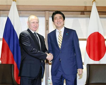 会談冒頭、ロシアのプーチン大統領（左）と握手を交わす安倍首相＝１５日午後、山口県長門市（代表撮影）