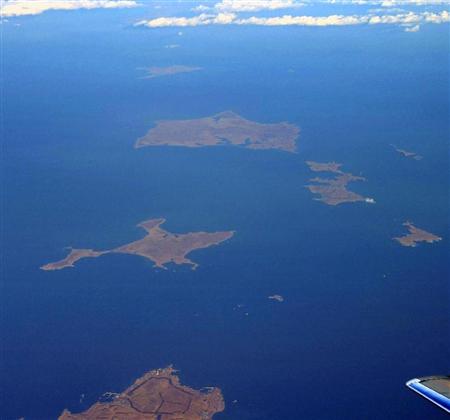 北海道・根室半島の納沙布岬（左下）沖に浮かぶ北方領土の歯舞群島。先にある色丹島は雲に遮られ肉眼では望めなかった＝３日、北海道根室市