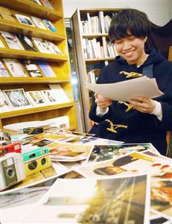 レンズ付きフィルムで撮影した写真を眺める北川拳汰さん＝東京都目黒区