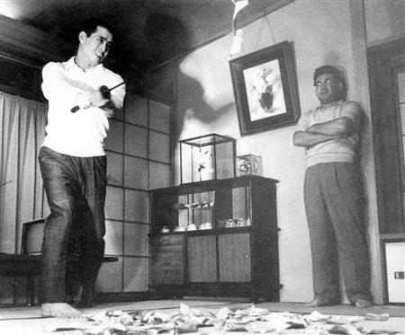 日本刀を使って王貞治（左）への打撃指導をする巨人コーチの荒川博氏＝１９６４年夏、東京都中野区の自宅で（同氏提供）