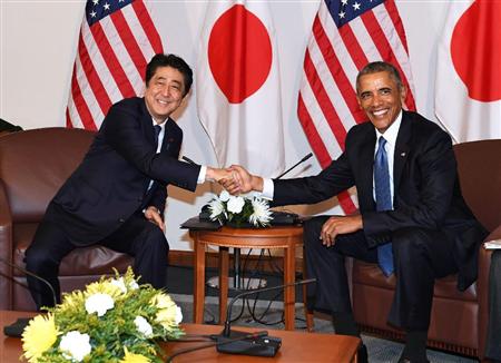 会談を前にオバマ米大統領（右）と握手する安倍首相＝２７日、米ハワイの米太平洋軍司令部（共同）