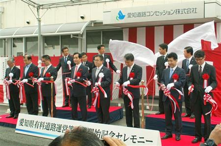 愛知県道路公社保有の有料道路が民営化され、記念式典でテープカットする大村秀章知事（前列右から４人目）ら＝昨年１０月１日、愛知県半田市
