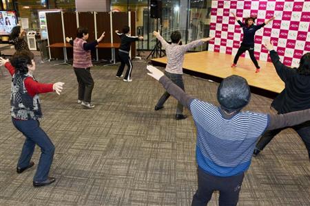 東京都江戸川区のイオン葛西店でインストラクターを手本に体操する高齢者