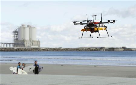 １０キロ超を完全自律制御で試験飛行し、海岸線で待つサーファーに飲み物を届けるドローン＝１２日、福島県南相馬市の北泉海水浴場