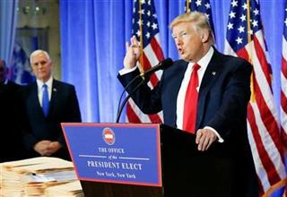 ニューヨークのトランプタワーで記者会見するトランプ次期米大統領。奥はペンス次期米副大統領＝１１日（ロイター＝共同）