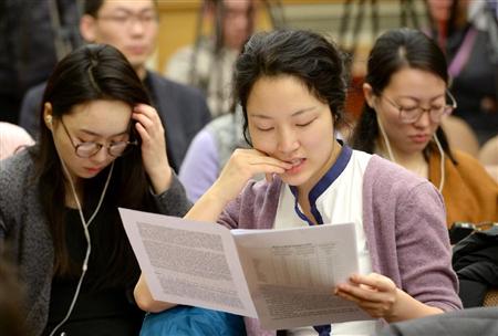 中国国家統計局の記者会見前に配られたＧＤＰ速報値の資料を読む報道関係者＝２０日、北京（共同）