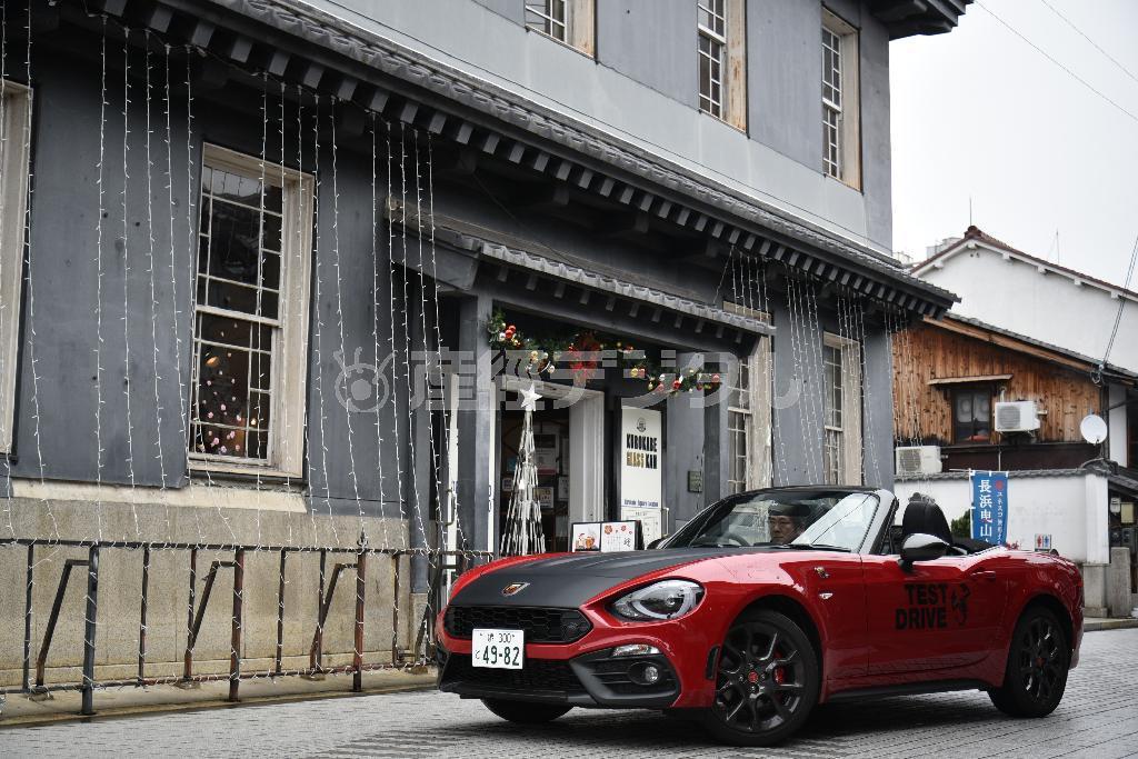 黒壁スクエアの中心部にある洒落た洋館「黒壁ガラス館」前にて。アバルト・１２４スパイダー