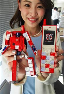KDDIの携帯電話「インフォバー」が、タカラトミーの「トランスフォーマー」の人気キャラクターに変形する玩具「インフォバーオプティマスプライム」。携帯電話の着信を知らせる機能もある KDDIの携帯電話「インフォバー」が、タカラトミーの「トランスフォーマー」の人気キャラクターに変形する玩具「インフォバーオプティマスプライム」。携帯電話の着信を知らせる機能もある