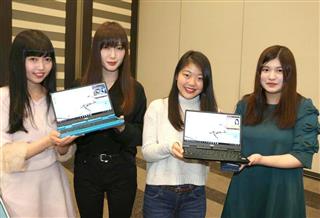 学生の声を反映した新商品のパソコンを披露する女子大生ら＝７日、東京都中央区