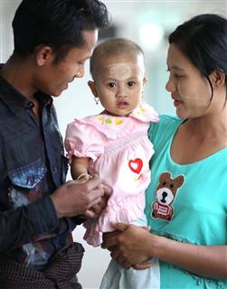 カテーテル治療を受けた女児、ピョー・ピョー・ルイちゃんと両親＝９日午後、ミャンマー・ヤンゴンの国立ヤンキン子供病院（福島範和撮影）