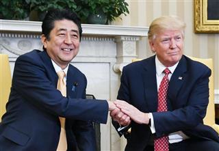 ドナルド・トランプ米大統領（右）と握手する安倍晋三首相＝１０日、ワシントンのホワイトハウス（共同）