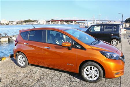 青い海を背景にオレンジボディが鮮やかに映える。後ろは城ケ島大橋