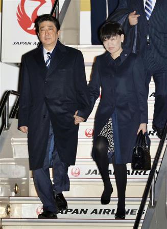 米国から帰国し、羽田空港に到着した安倍晋三首相。右は昭恵夫人＝１３日