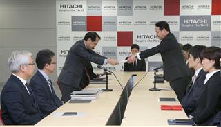 日立製作所の中畑英信執行役常務（左）に、要求書を手渡す日立労組の坂本達哉中央執行委員長＝１６日、東京都千代田区