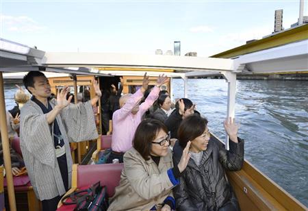 「プレミアムフライデー」が始まった２４日、夕暮れ時を遊覧船の上で過ごす仕事帰りの人たち。左端は落語家の桂優々さん＝２４日午後、大阪市