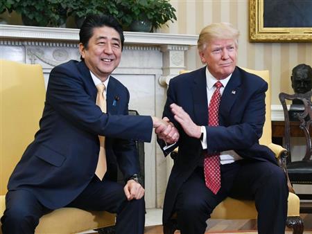 トランプ米大統領（右）と握手する安倍首相＝１０日、ワシントンのホワイトハウス（共同）