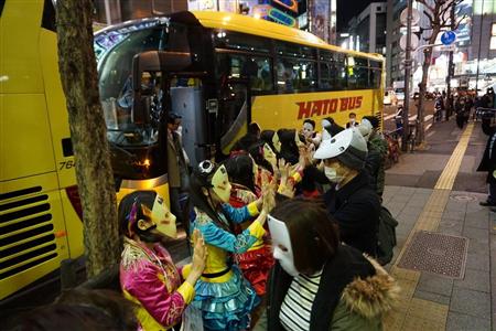 はとバスツアーに一緒に乗り込み、仮面女子メンバーとハイタッチして親交を深めたファンら＝２４日、東京・秋葉原