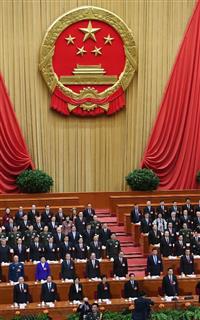 全人代が開幕し、国歌斉唱する代表＝５日、北京の人民大会堂（共同）