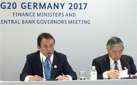 Ｇ２０財務相・中央銀行総裁会議閉幕後に記者会見する麻生財務相。右は日銀の黒田総裁＝１８日、ドイツ南西部バーデンバーデン（共同）